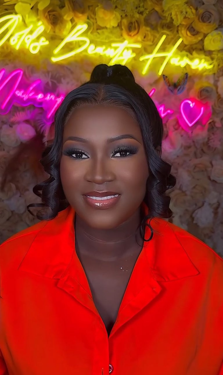 Warm glam makeup look with curled hair and orange satin outfit